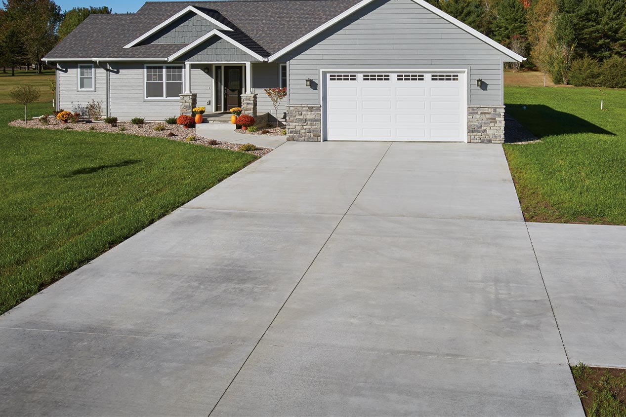 Wide smooth finish concrete driveway leading to the garage